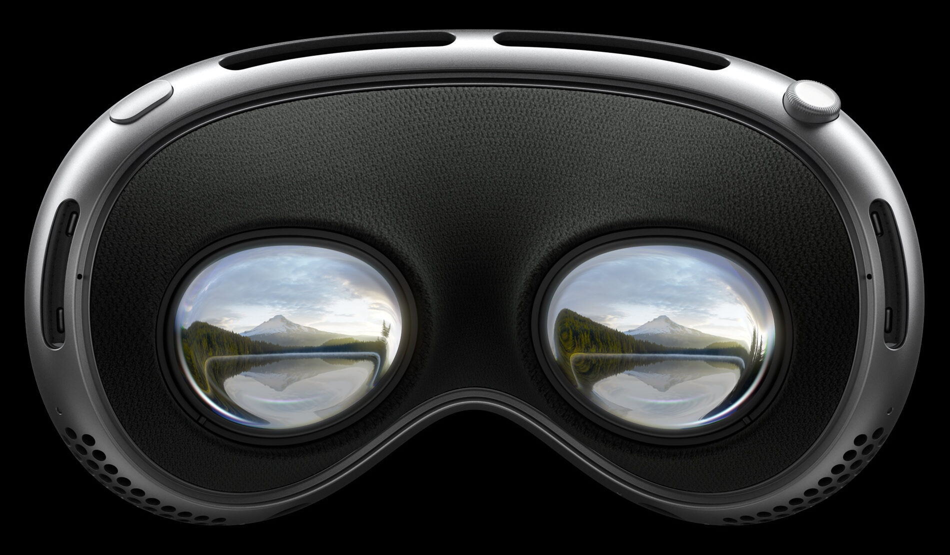 Apple Vision Pro seen from within: two micro-OLED lenses holding a landscape, framed in aluminum on black